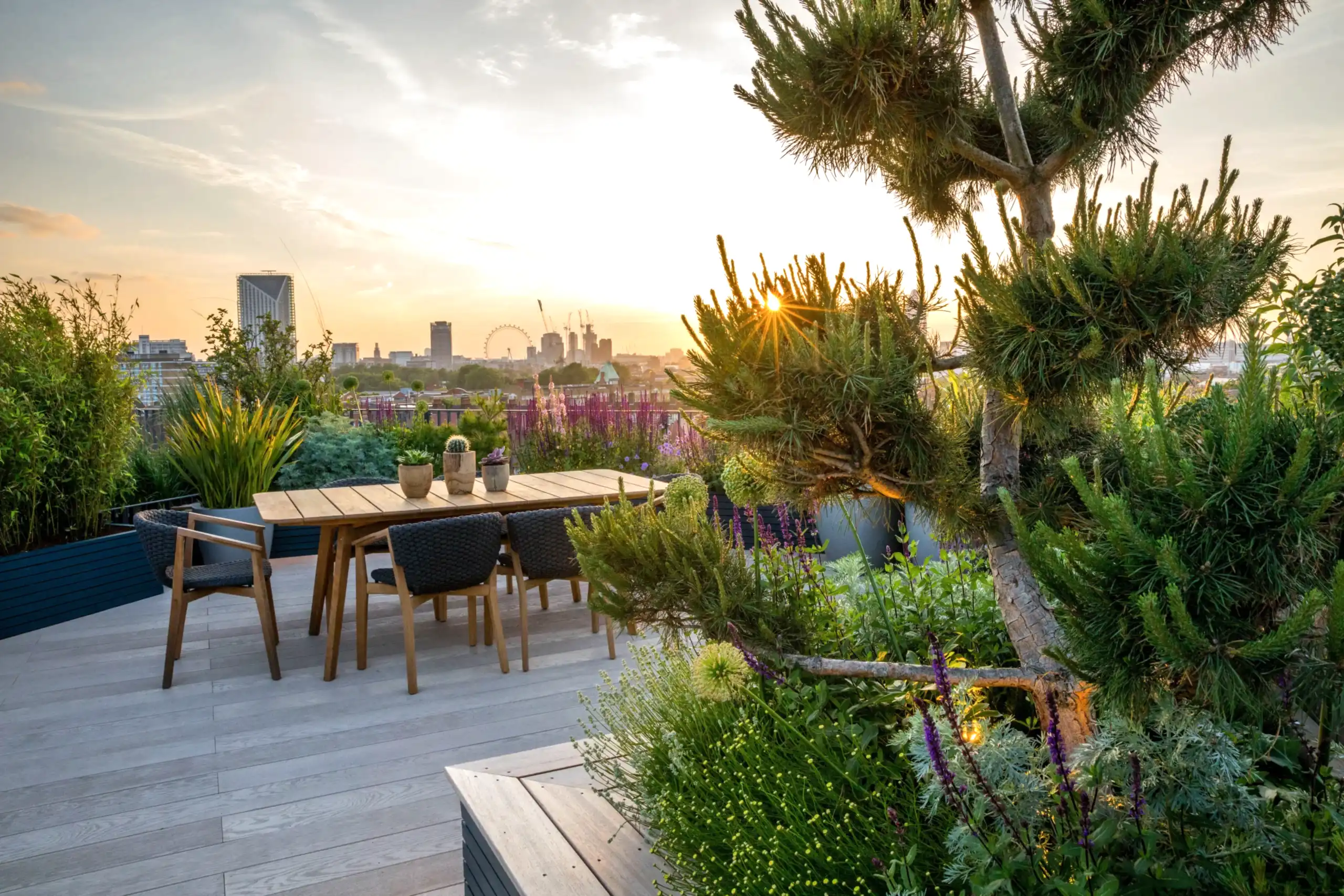 a table and chairs on a deck with a city in the background