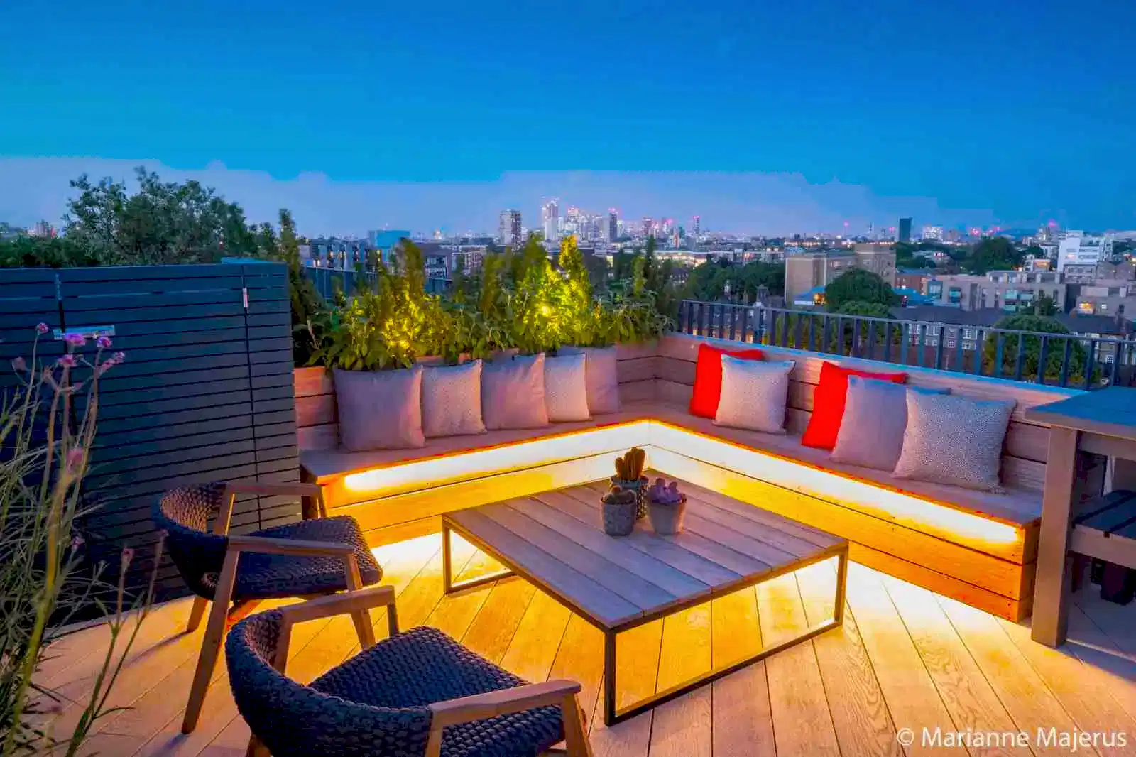 Stylish rooftop garden overlooking London at night