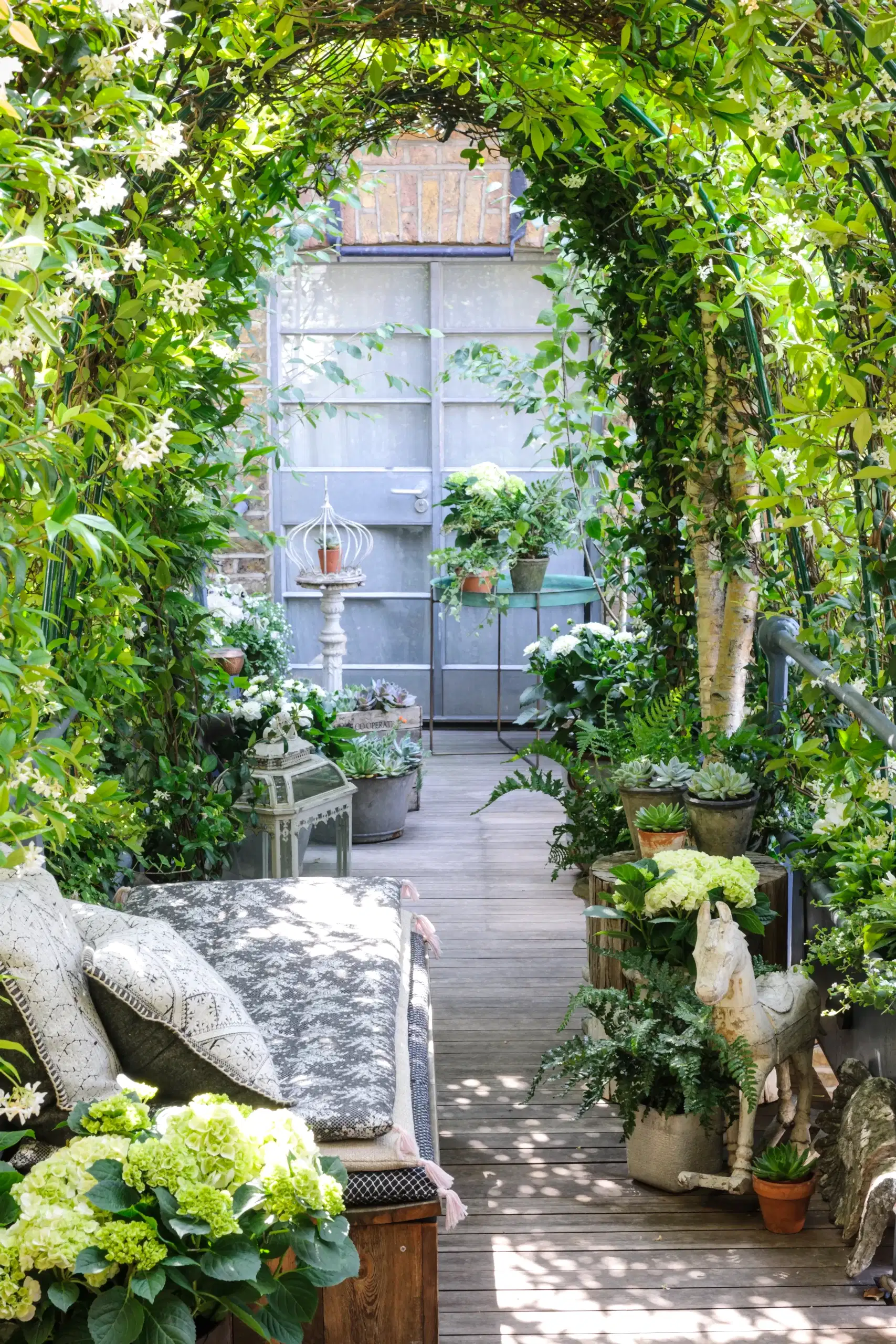 a patio with plants and a bench