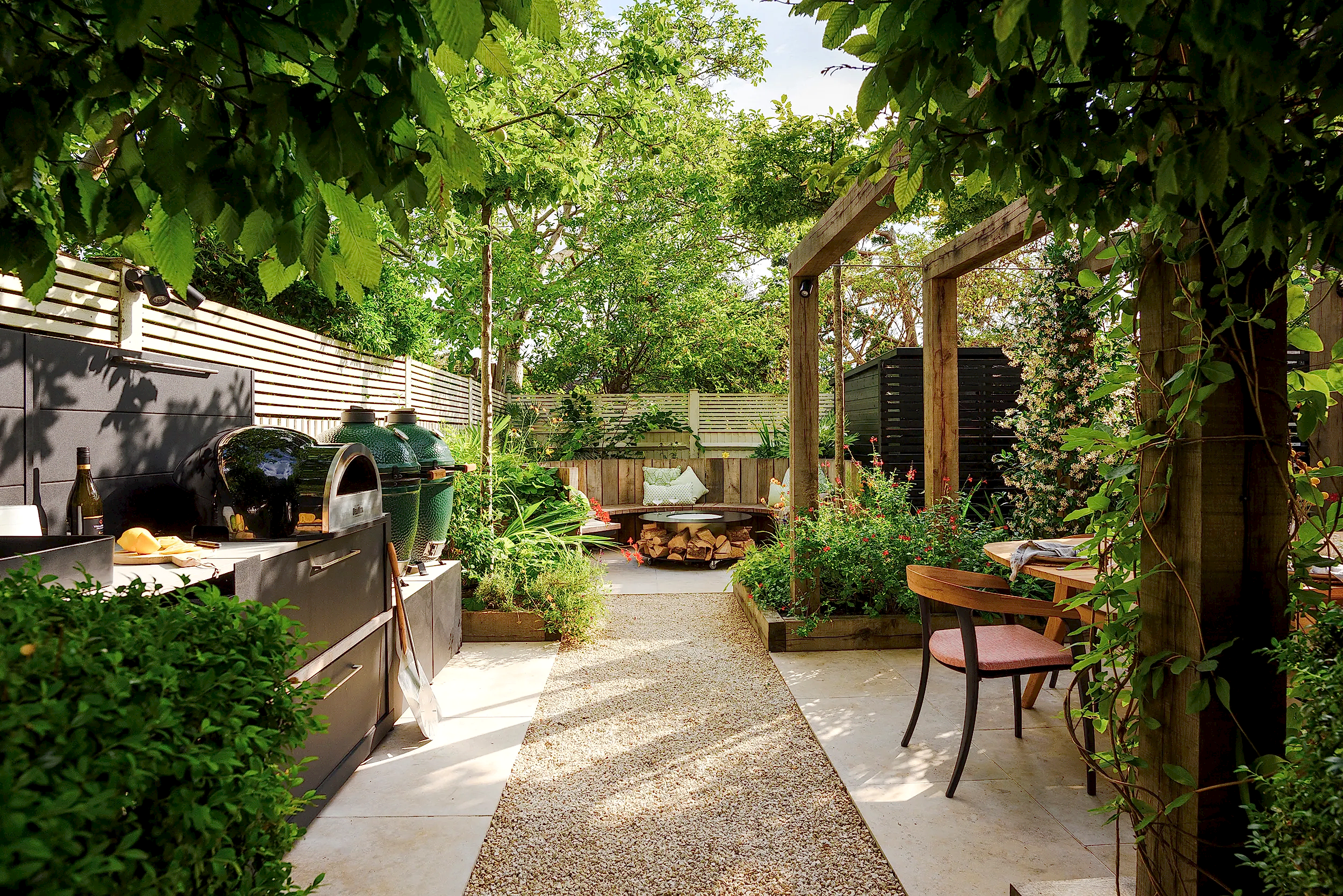 Outdoor kitchen with pizza oven, big green egg, fridge and pergola