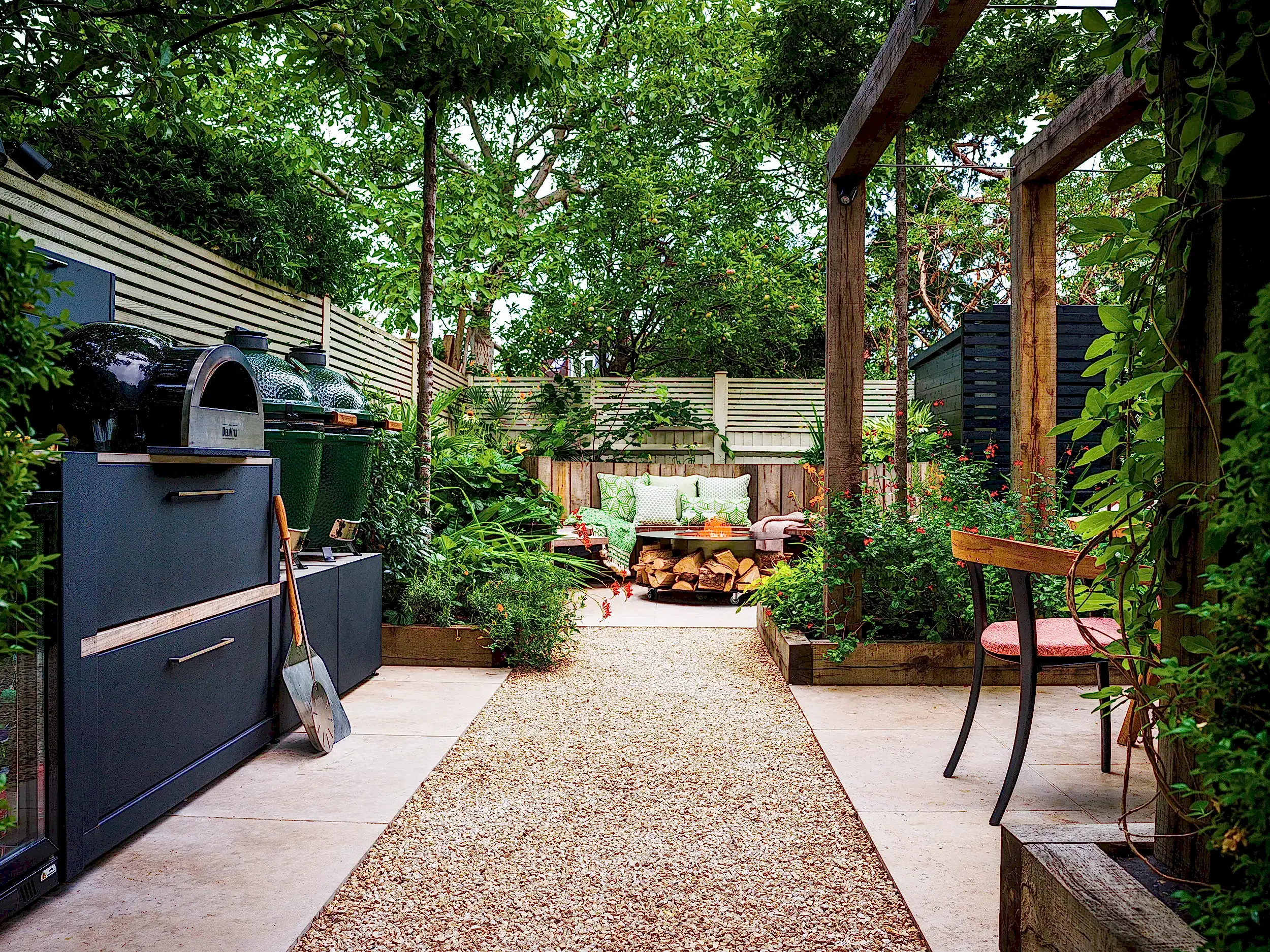 Outdoor kitchen with pizza oven, big green egg, fridge and pergola