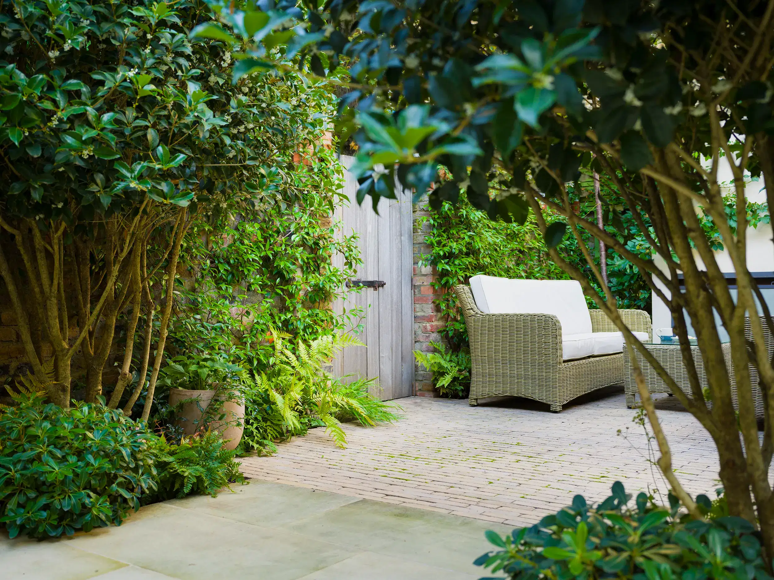 a patio with a white couch and a wood door