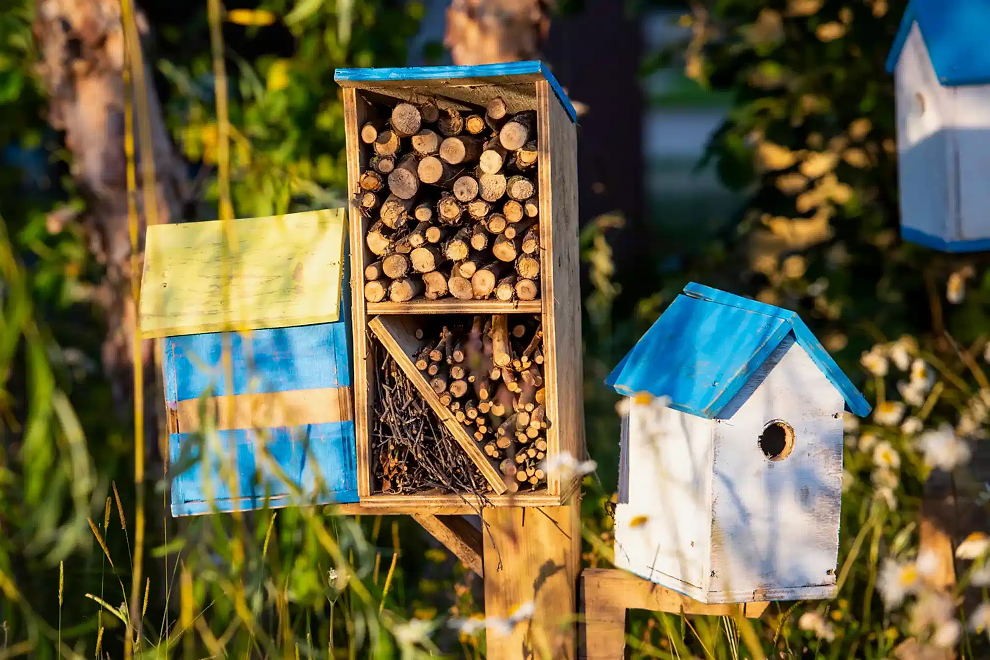 a bird house with wood logs and a blue roof