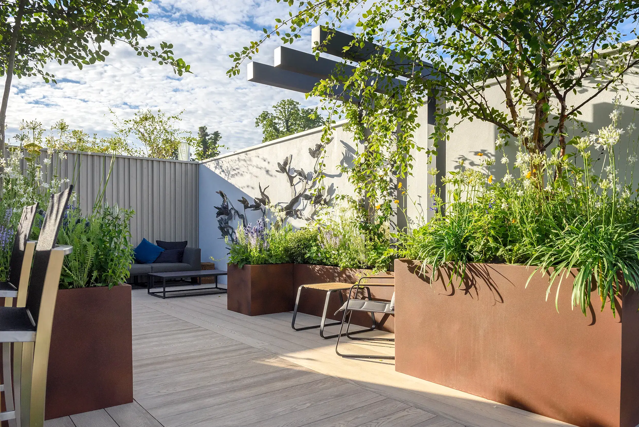 a patio with plants and a bench