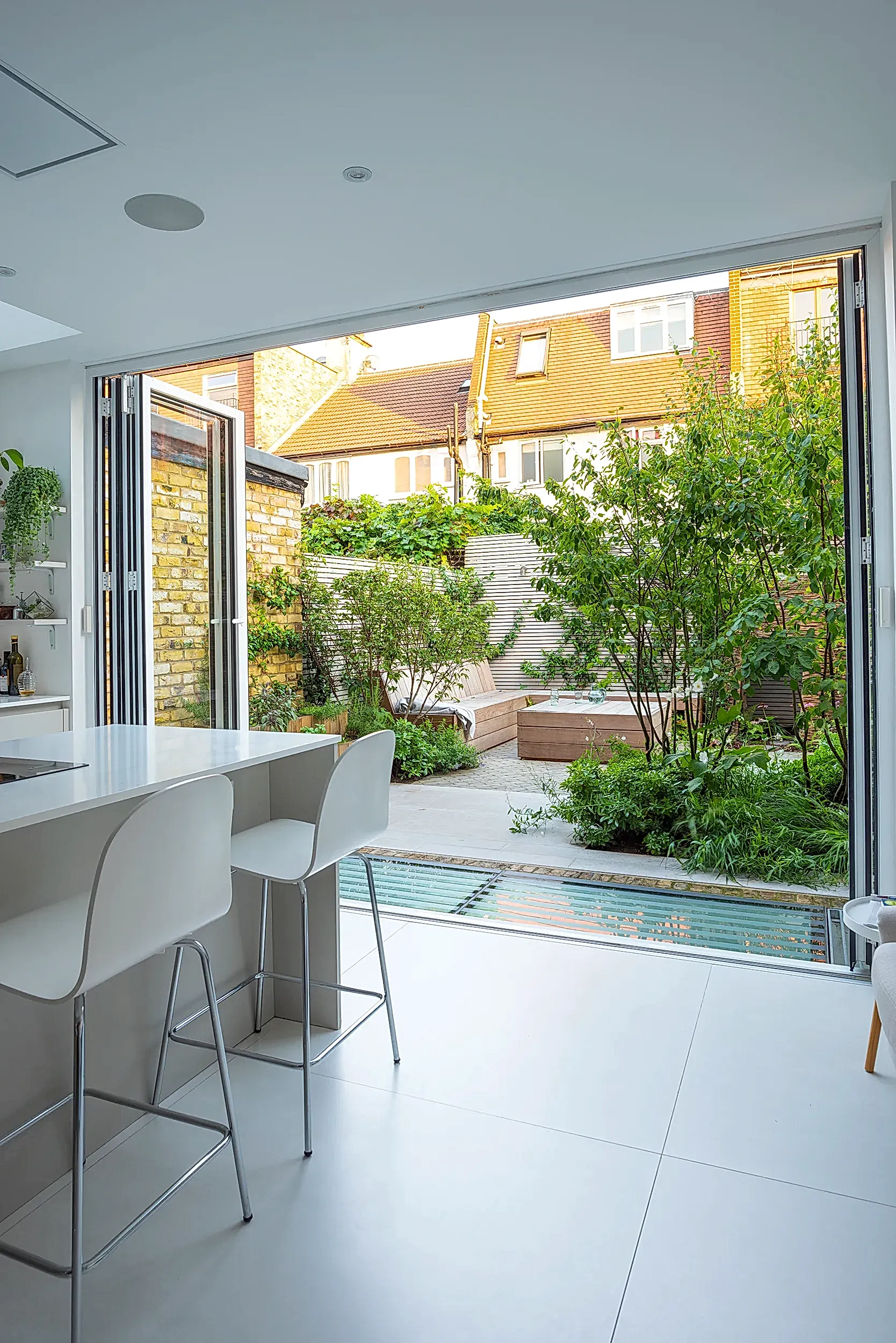 a kitchen with a bar and chairs in a house with a pool