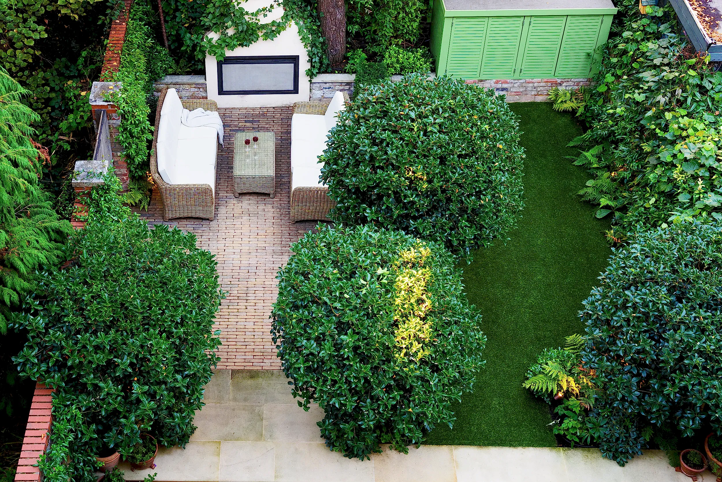 Small garden designed for both adults and children with lawn, fireplace, trees and seating area