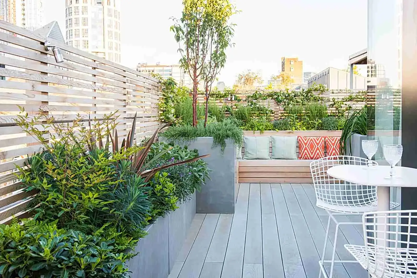 a patio with a bench and plants