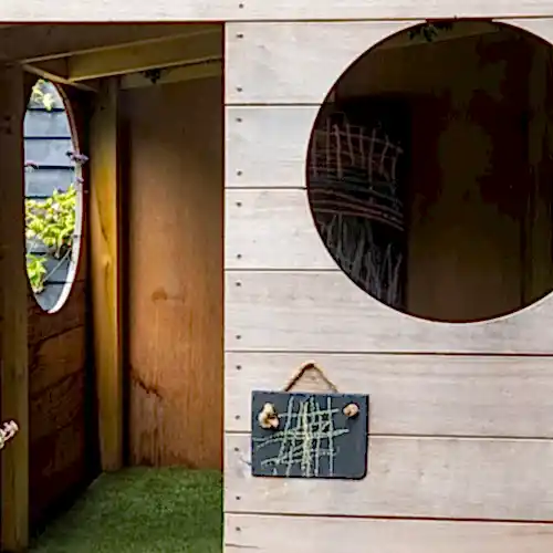 a wooden playhouse with round windows