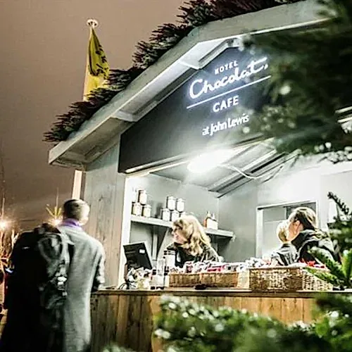 a group of people standing outside a cafe