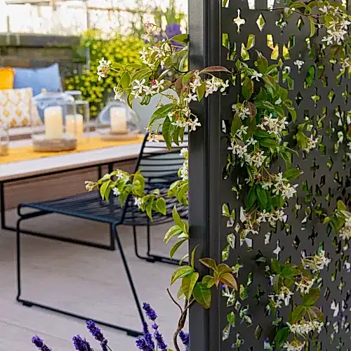 a metal fence with white flowers and a table