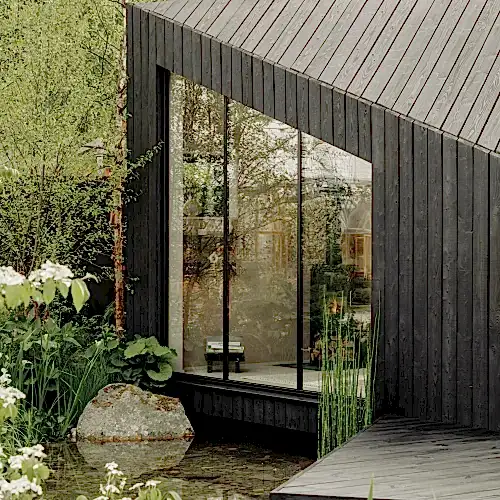 Charred larch contemporary garden studio with planting and pond