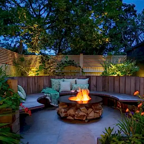 a fire pit with benches and a wood fence