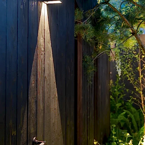 a light shining on a wooden fence