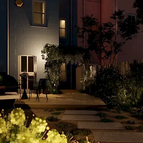 a patio with chairs and a table in front of a building at night