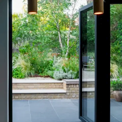 a glass door open to a garden