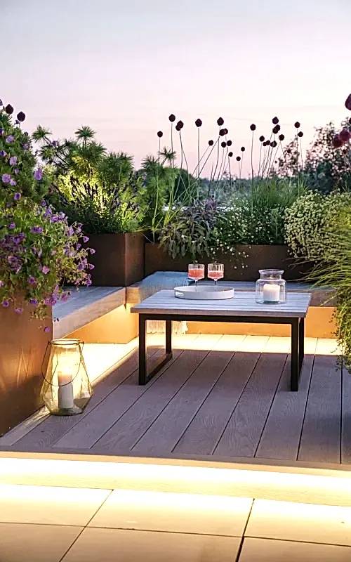 a table with candles on it and plants in the background