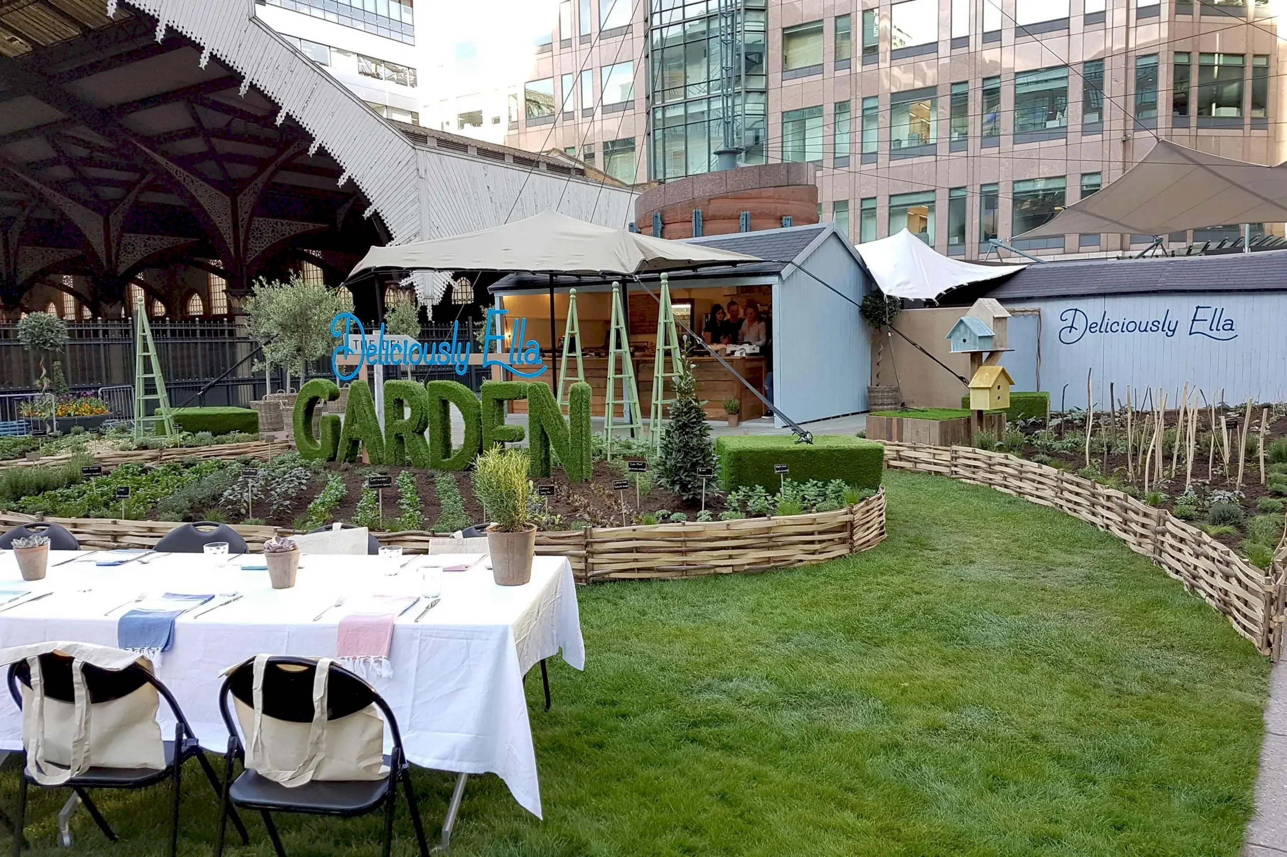 a garden with tables and chairs in front of a building