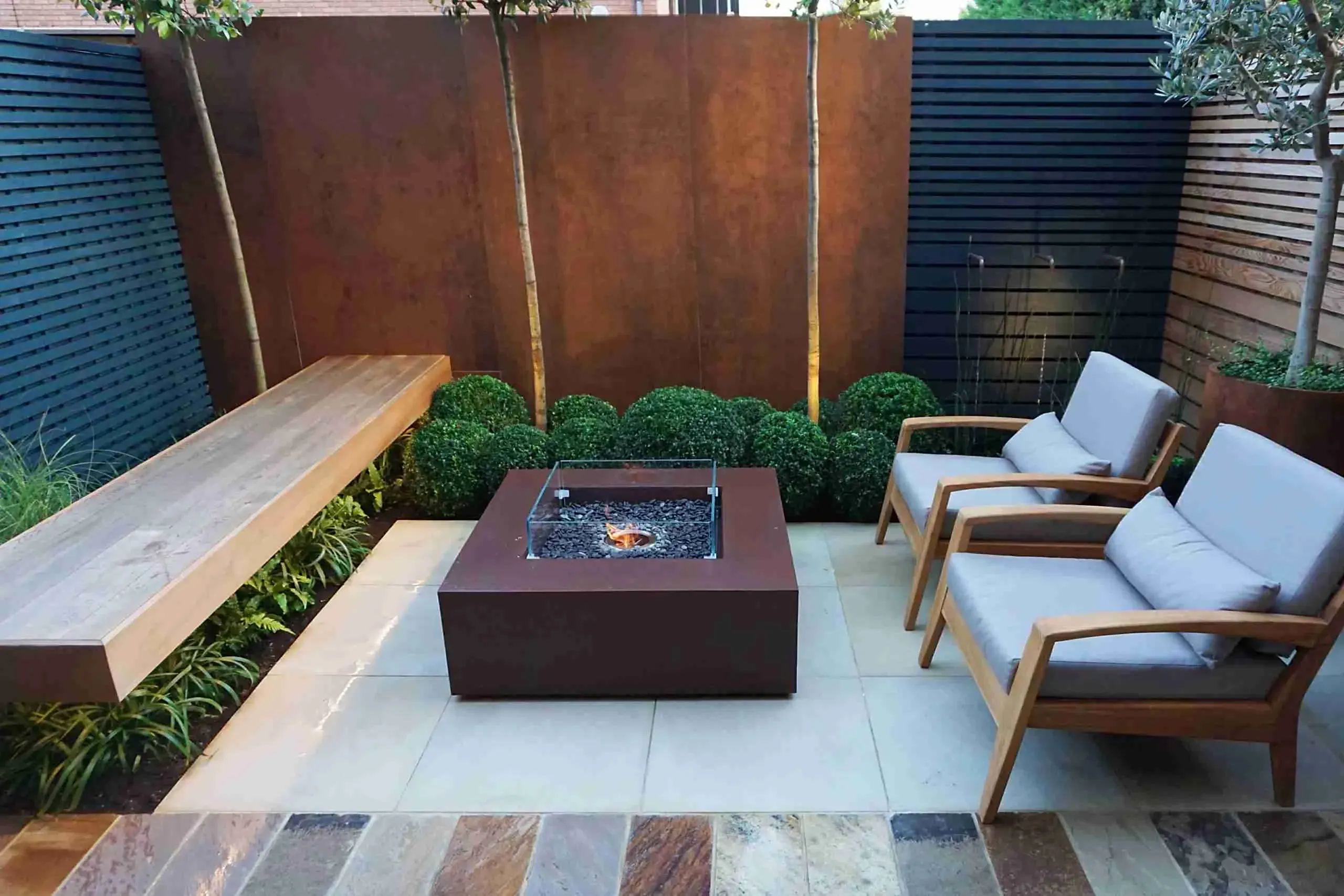 a patio with a fire pit and chairs