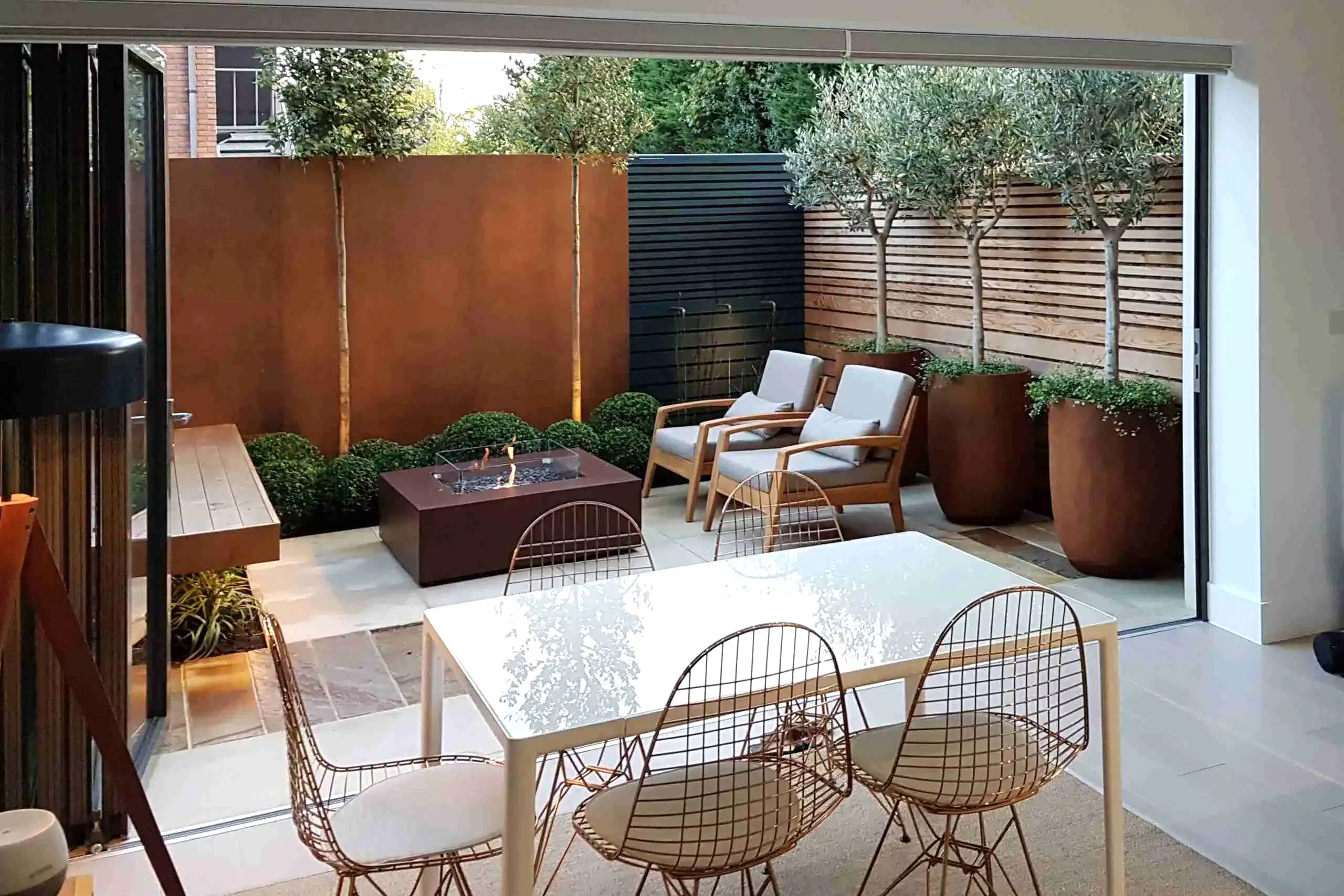 a patio with chairs and a fire pit