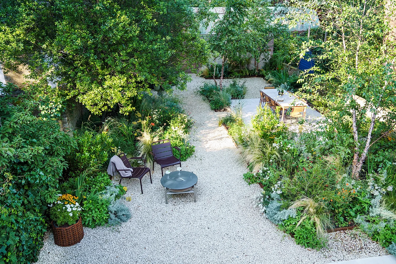 a patio area with chairs and tables surrounded by trees