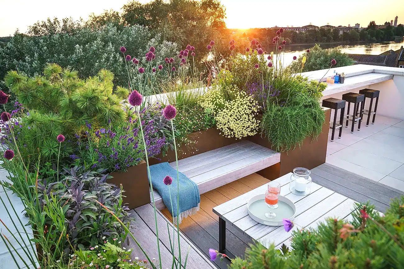 a deck with a table and chairs and plants