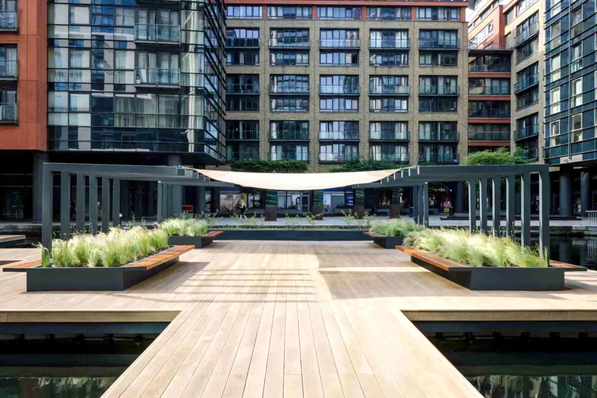 a wooden deck with plants in front of a building