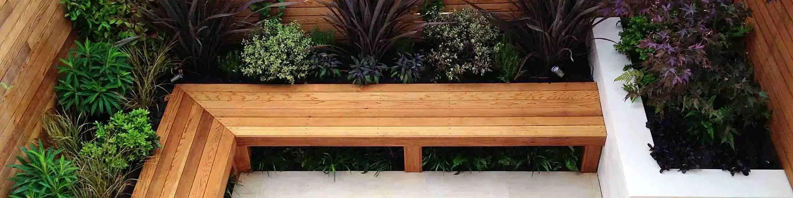 a wooden bench with plants around it